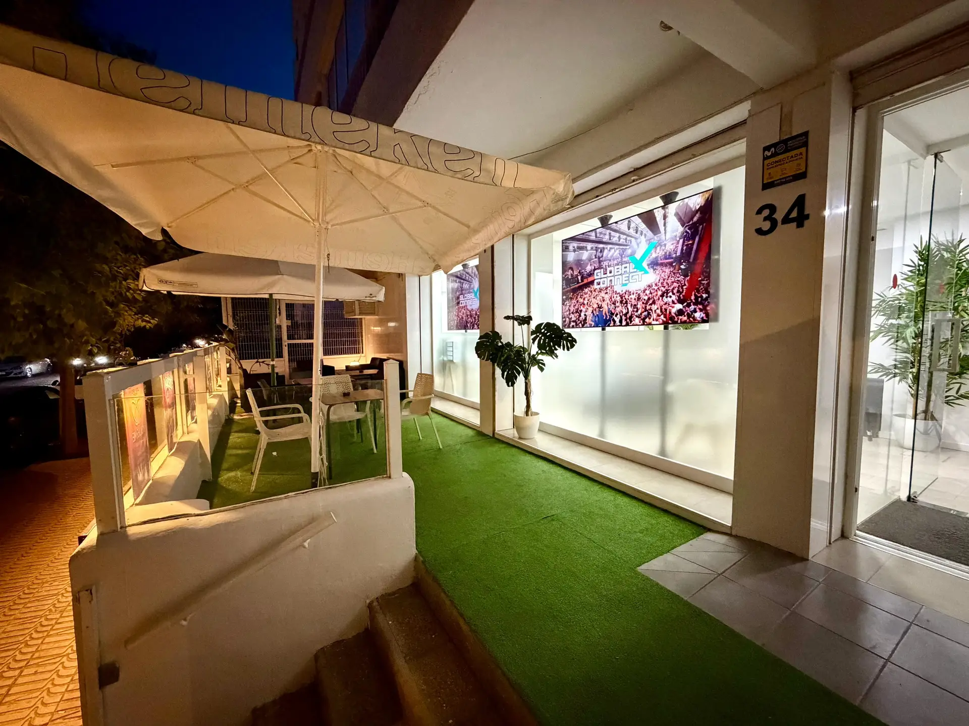 GXC Ibiza office terrace at night with event screens
